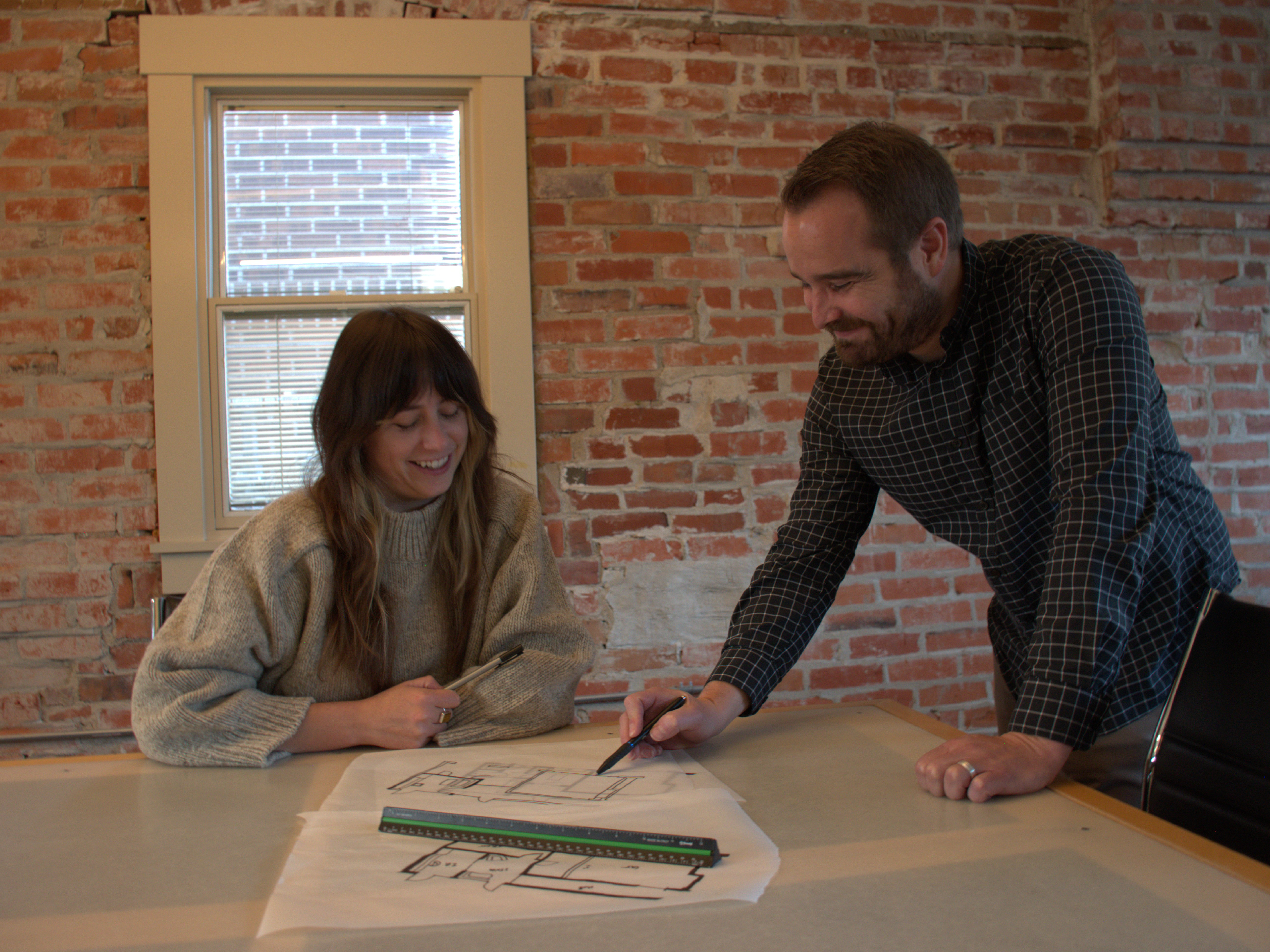 Architects reviewing hand sketches with a client during an early design meeting