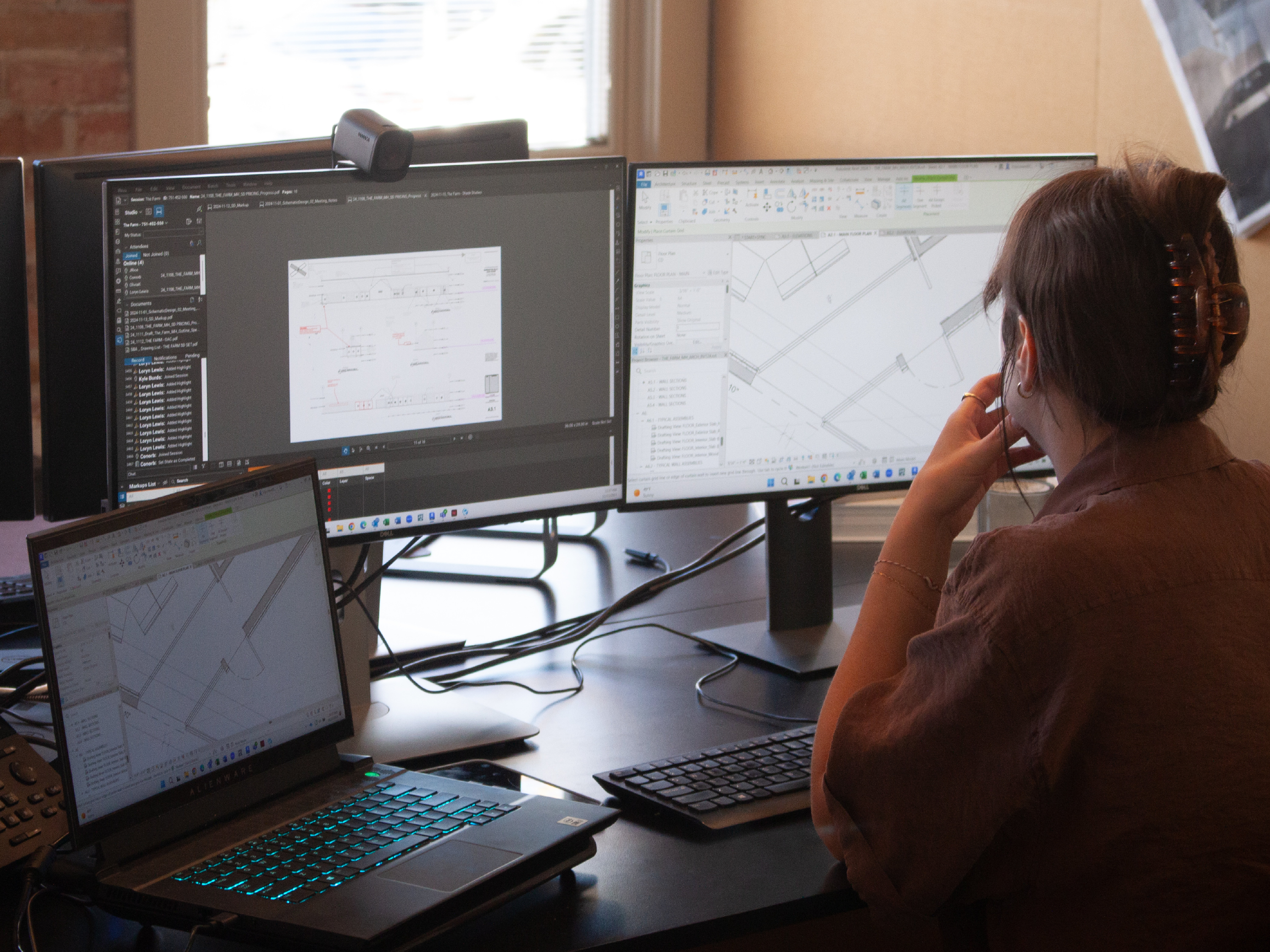 Architect working in BIM software developing detailed building plans on dual monitors
