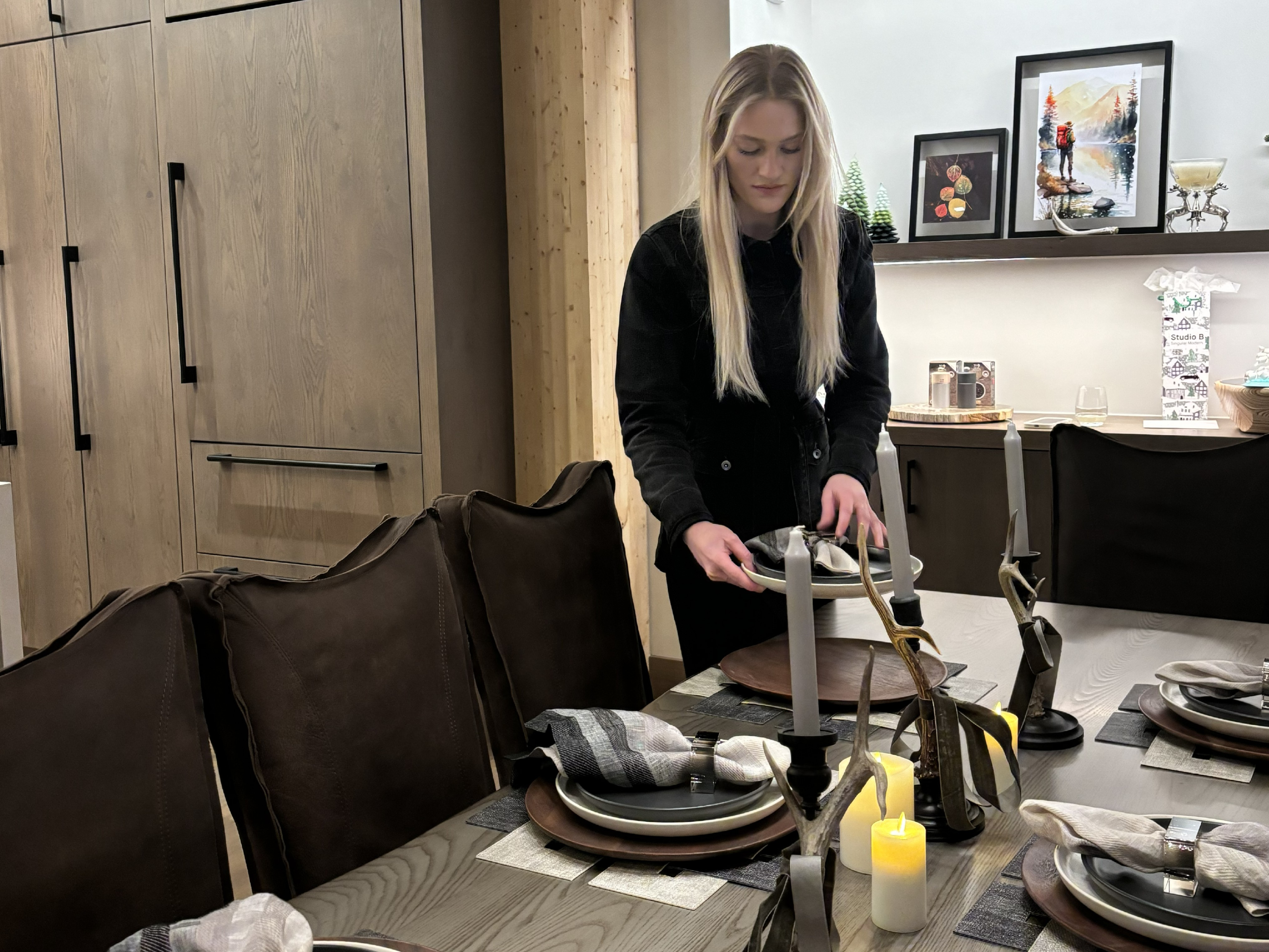 Interior designer styling a dining table with layered materials and objects