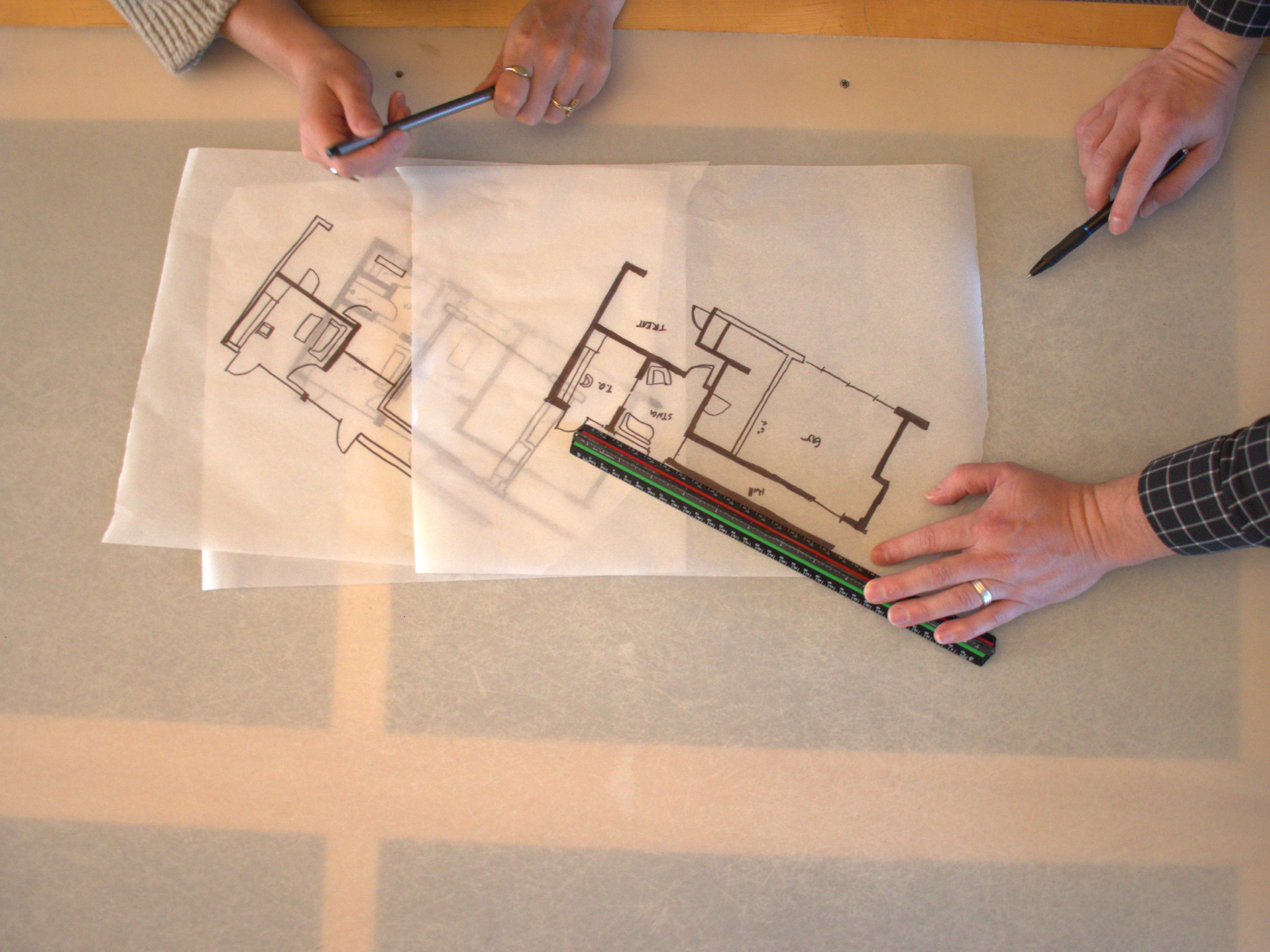 Layered trace paper floor plans showing iterative design development process