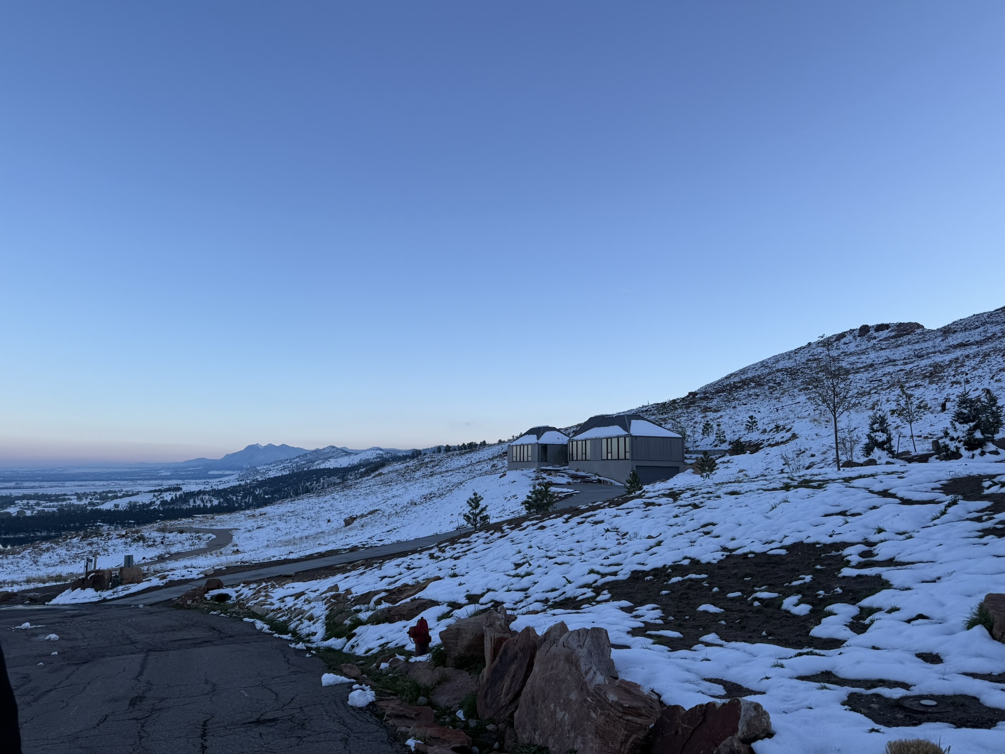 Exterior view of the Mountain Ridge residence at twilight with snow-covered hillsides and expansive Colorado mountain surroundings.